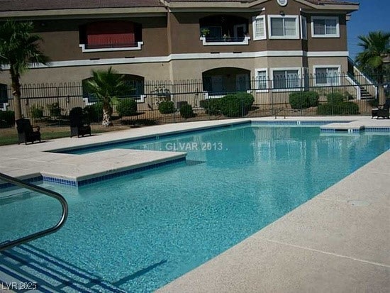 pool featuring fence and a patio area