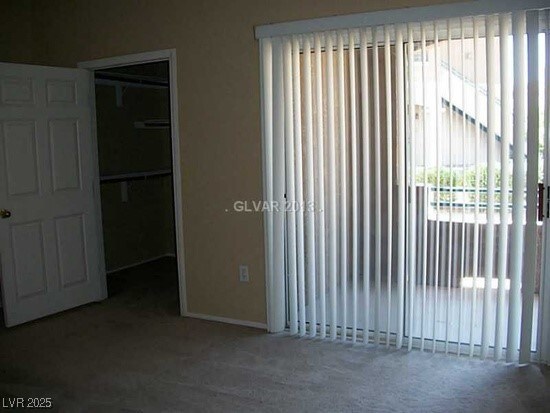 unfurnished bedroom with carpet floors, baseboards, a spacious closet, and a closet