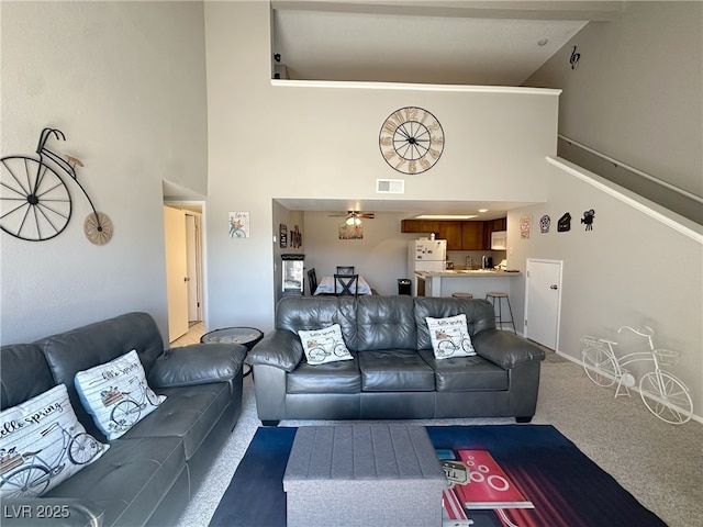 living area featuring carpet flooring, a ceiling fan, high vaulted ceiling, and visible vents