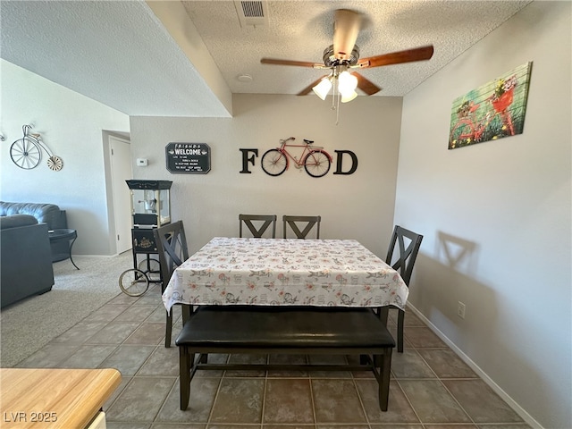 tiled dining space with a textured ceiling, ceiling fan, and visible vents