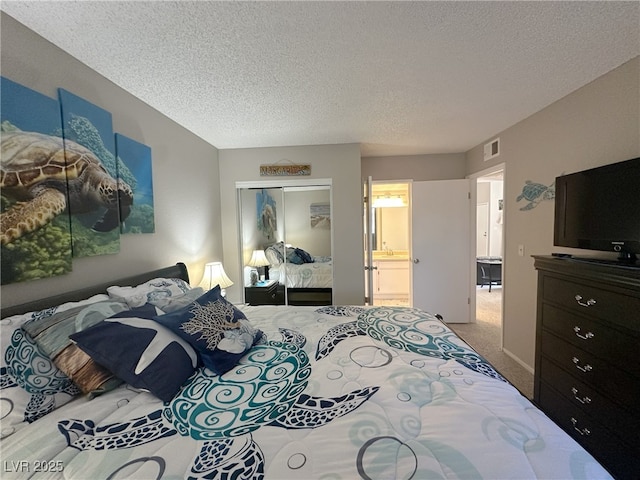 carpeted bedroom with a textured ceiling, visible vents, connected bathroom, and a closet