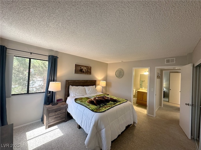 bedroom with a textured ceiling, visible vents, and light colored carpet