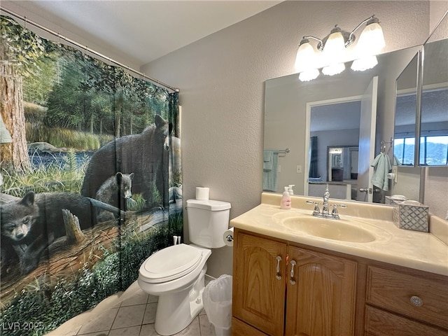bathroom featuring vanity, toilet, a textured wall, tile patterned flooring, and a shower with shower curtain