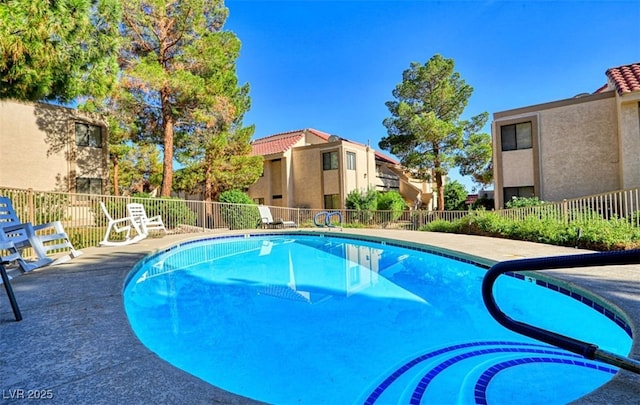 pool with fence and a residential view
