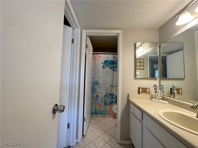 bathroom featuring tile patterned floors, a textured ceiling, vanity, and toilet