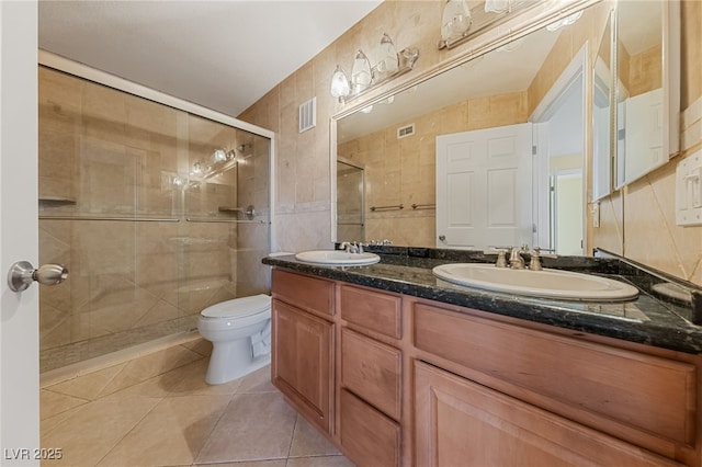 7950 W Flamingo Rd Unit 2066, Las Vegas, NV 89147 - bathroom with a stall shower, double vanity, tile patterned flooring, toilet, and tile walls