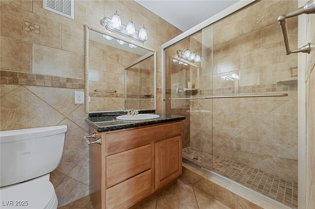 7950 W Flamingo Rd Unit 2066, Las Vegas, NV 89147 - bathroom with toilet, vanity, tile walls, a shower stall, and tile patterned flooring