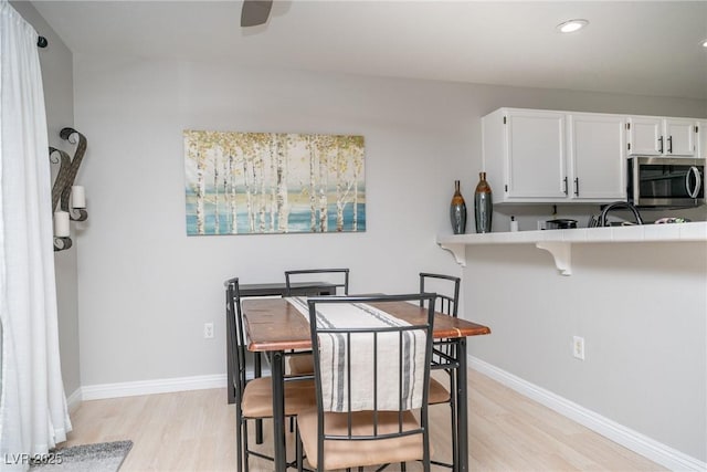 dining space featuring recessed lighting, ceiling fan, baseboards, and light wood-style floors