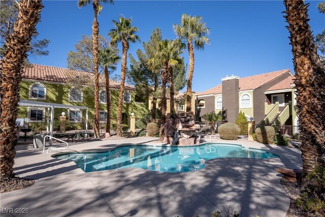 view of swimming pool featuring a patio, fence, and a fenced in pool