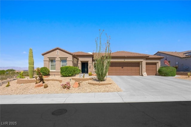 single story home with a tile roof, stucco siding, driveway, and an attached garage