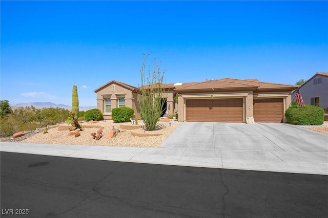 view of front of home featuring concrete driveway, an attached garage, and stucco siding