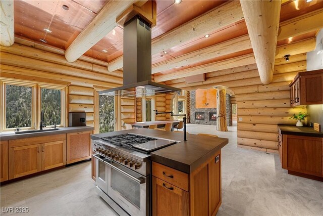 kitchen with double oven range, dark countertops, a sink, wooden ceiling, and log walls