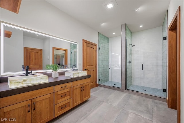 full bathroom featuring a shower stall, double vanity, tile patterned floors, and recessed lighting