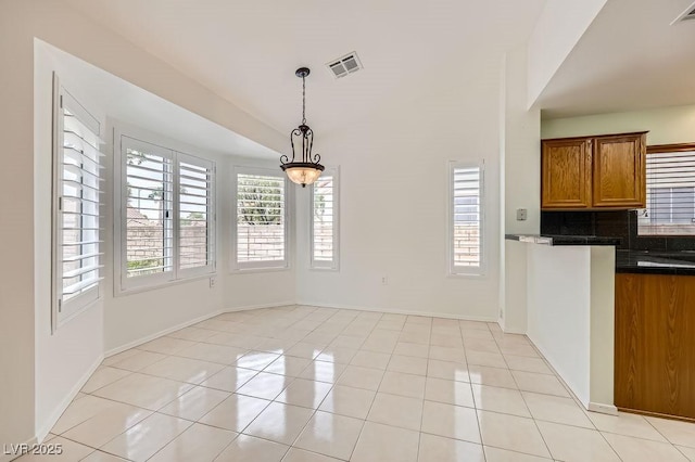 unfurnished dining area with light tile patterned floors, visible vents, and baseboards