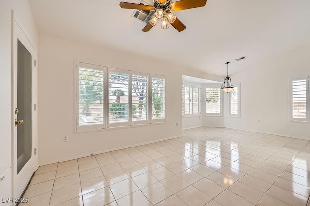 empty room with baseboards, light tile patterned floors, ceiling fan, visible vents, and vaulted ceiling