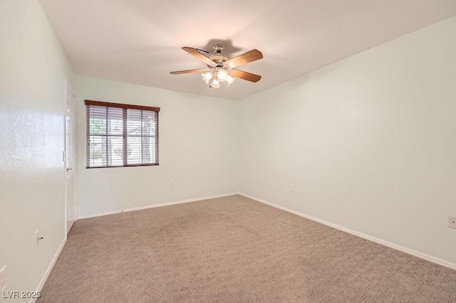 carpeted spare room with baseboards and a ceiling fan