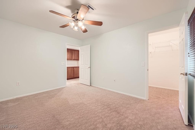unfurnished bedroom featuring a spacious closet, a closet, and light colored carpet