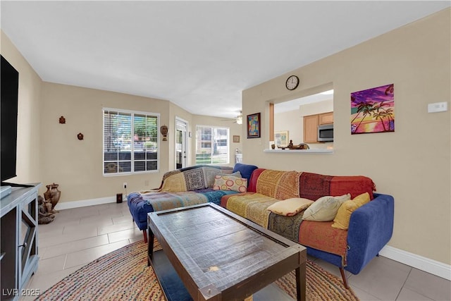 living area featuring light tile patterned flooring and baseboards