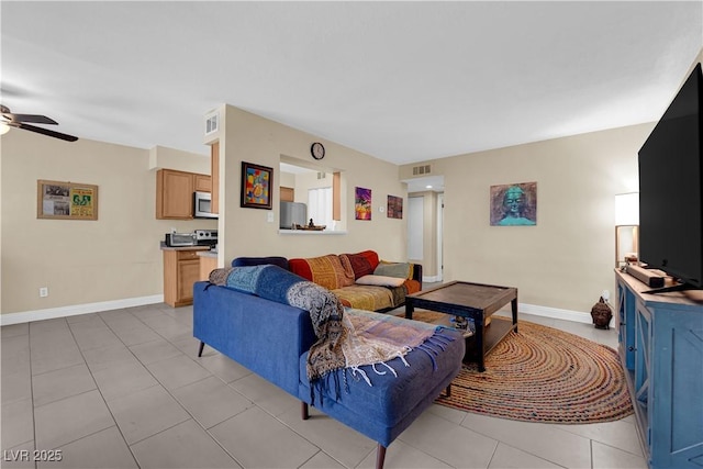 living area with light tile patterned floors, ceiling fan, visible vents, and baseboards
