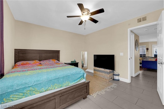 tiled bedroom featuring a ceiling fan, visible vents, and baseboards