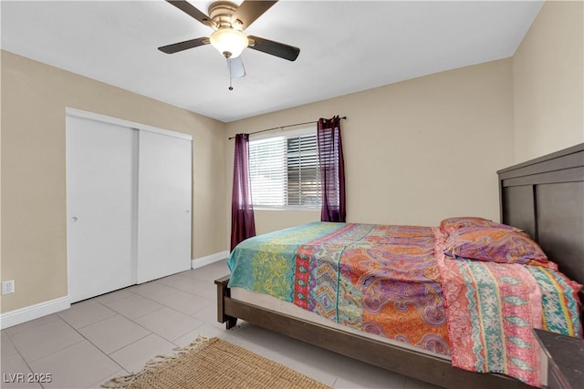 bedroom featuring tile patterned floors, ceiling fan, a closet, and baseboards