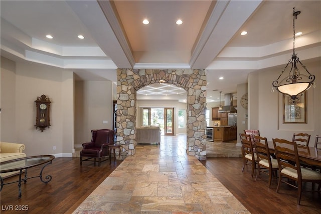 entrance foyer featuring recessed lighting, ornate columns, baseboards, arched walkways, and dark wood finished floors