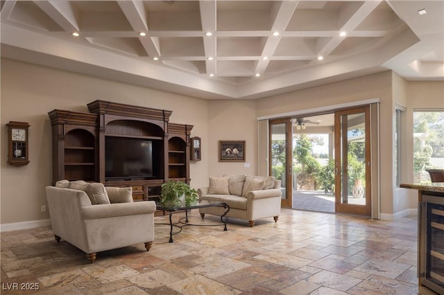 living room featuring stone tile floors, baseboards, recessed lighting, wine cooler, and a high ceiling