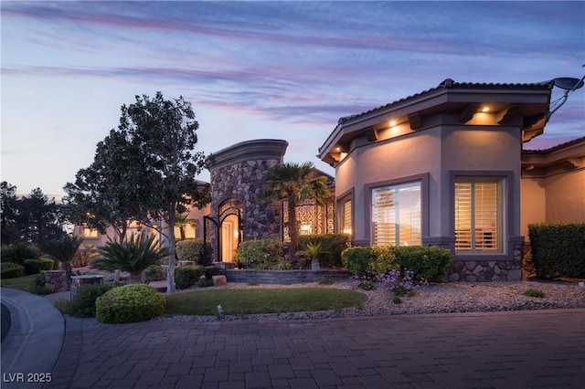 view of front of house featuring stone siding and stucco siding