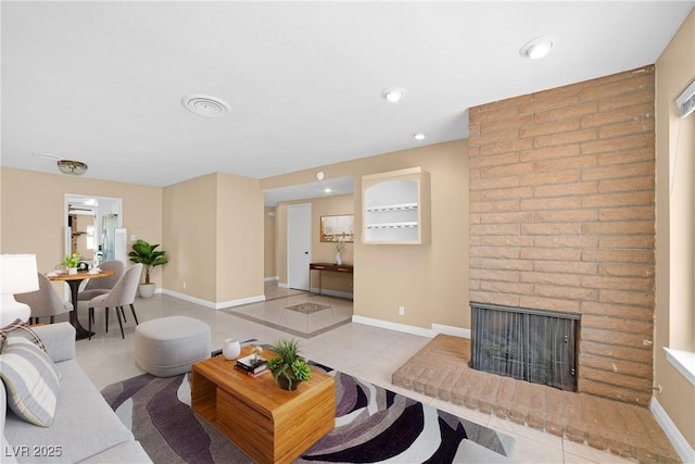 living room with a brick fireplace, recessed lighting, baseboards, and tile patterned flooring