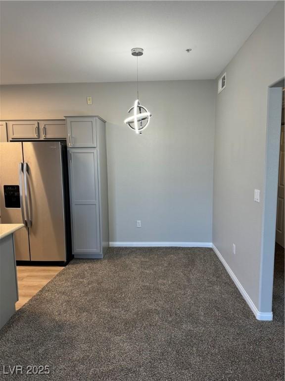 kitchen with gray cabinetry, visible vents, light carpet, and stainless steel fridge with ice dispenser