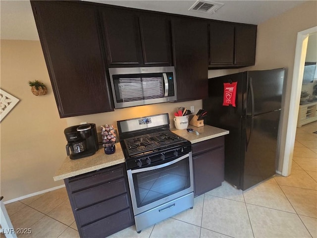 7328 Coffeyville Ave, Las Vegas, NV 89147 - kitchen with visible vents, stainless steel appliances, light tile patterned flooring, and light countertops