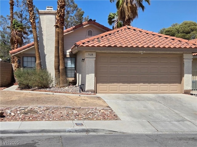 7328 Coffeyville Ave, Las Vegas, NV 89147 - mediterranean / spanish home featuring driveway, an attached garage, a tiled roof, and stucco siding