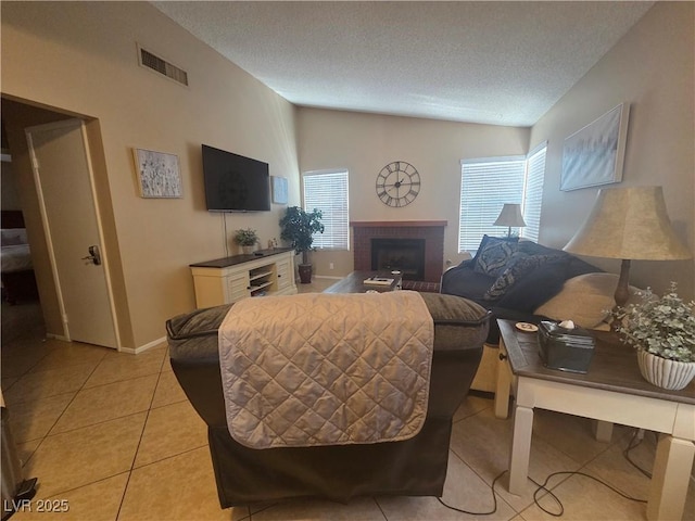 7328 Coffeyville Ave, Las Vegas, NV 89147 - living room with a textured ceiling, visible vents, baseboards, light tile patterned flooring, and a fireplace