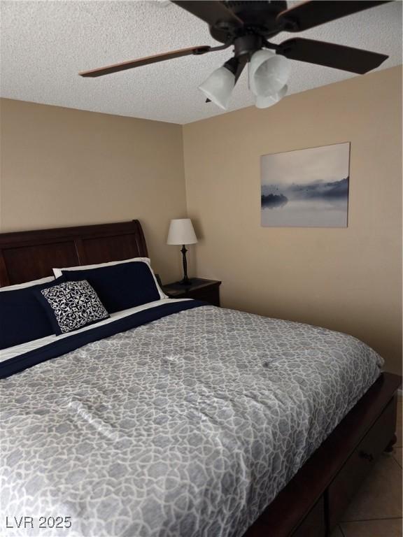 7328 Coffeyville Ave, Las Vegas, NV 89147 - tiled bedroom featuring ceiling fan and a textured ceiling