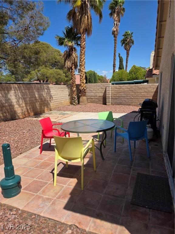 7328 Coffeyville Ave, Las Vegas, NV 89147 - view of patio with outdoor dining area, a grill, and a fenced backyard