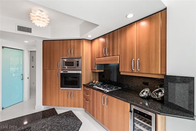2857 Paradise Rd Unit 305, Las Vegas, NV 89109 - kitchen with wall oven, wine cooler, gas stovetop, stainless steel microwave, and under cabinet range hood