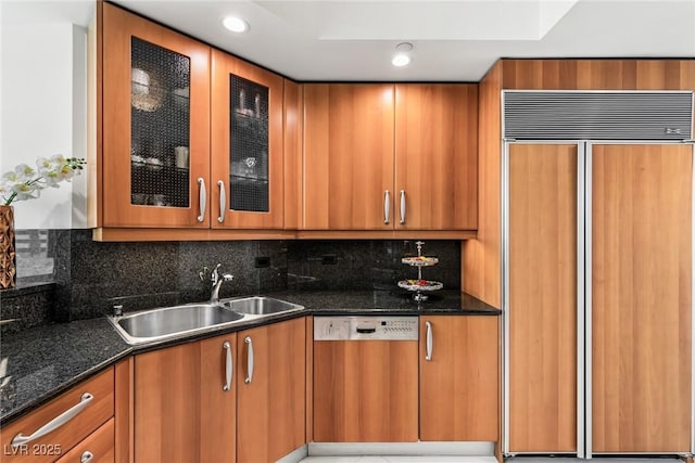 2857 Paradise Rd Unit 305, Las Vegas, NV 89109 - kitchen with paneled appliances, a sink, brown cabinets, dark stone countertops, and recessed lighting