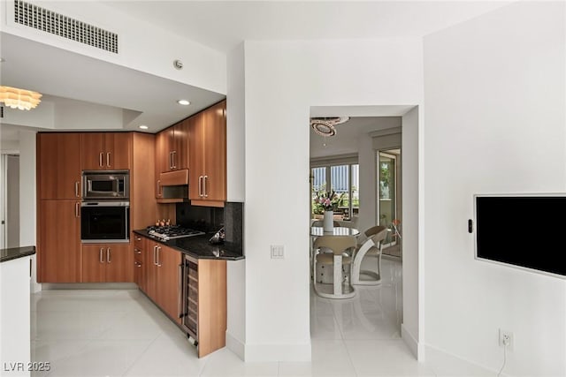 2857 Paradise Rd Unit 305, Las Vegas, NV 89109 - kitchen with appliances with stainless steel finishes, brown cabinetry, baseboards, wine cooler, and recessed lighting