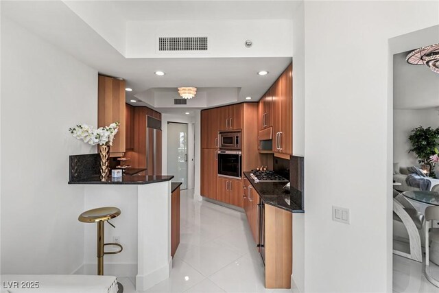 2857 Paradise Rd Unit 305, Las Vegas, NV 89109 - kitchen featuring stainless steel appliances, brown cabinetry, recessed lighting, a peninsula, and a breakfast bar