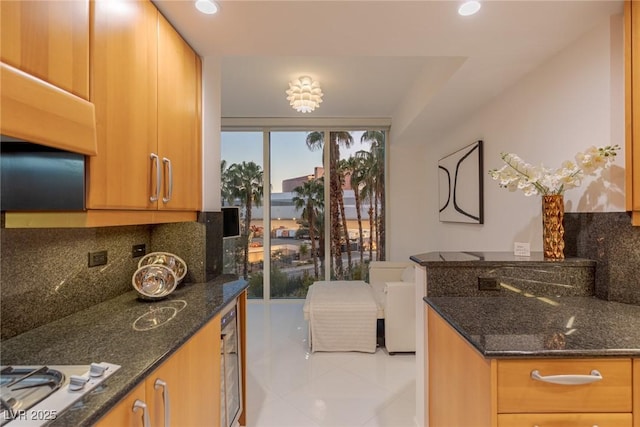 2857 Paradise Rd Unit 305, Las Vegas, NV 89109 - kitchen featuring decorative backsplash, tile patterned flooring, dark stone countertops, and recessed lighting