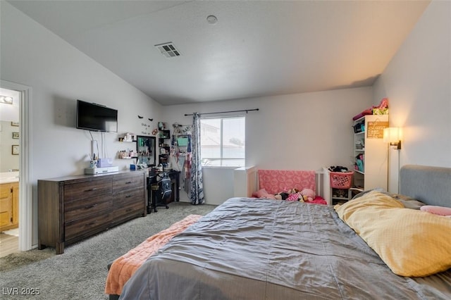 bedroom with visible vents, ensuite bathroom, carpet, and lofted ceiling