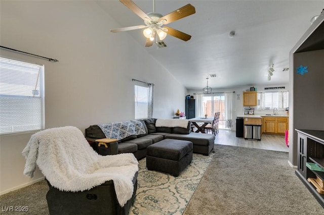 living area featuring ceiling fan, light carpet, high vaulted ceiling, and baseboards