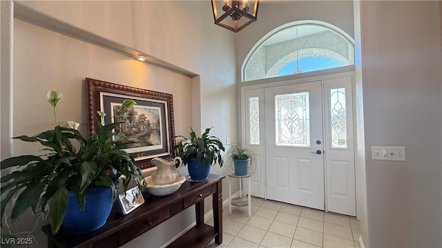 entryway with an inviting chandelier and light tile patterned flooring