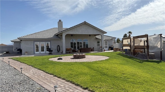 rear view of house featuring a ceiling fan, a patio, an outdoor fire pit, and french doors