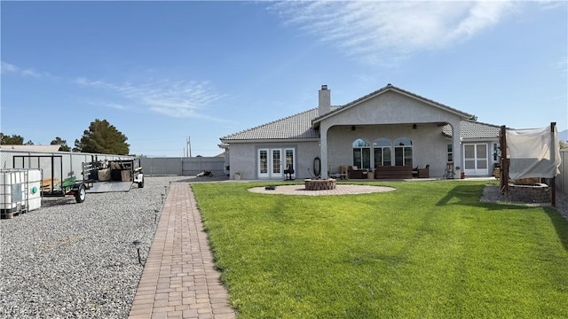 rear view of house with stucco siding, a chimney, ceiling fan, and a patio