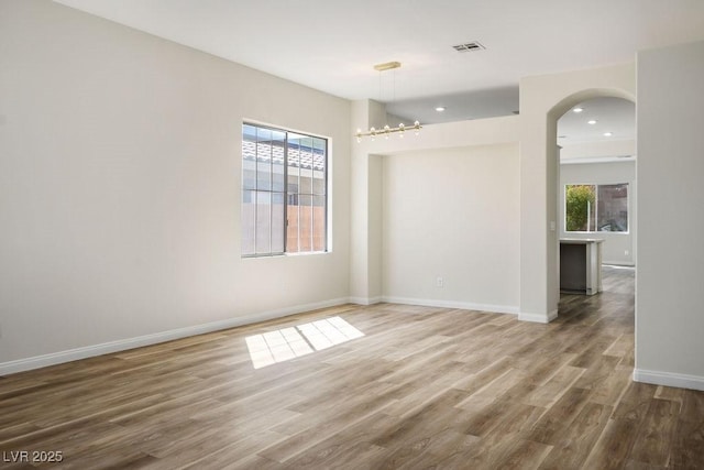 10657 Sapphire Vista Ave, Las Vegas, NV 89144 - spare room featuring recessed lighting, visible vents, baseboards, arched walkways, and wood finished floors