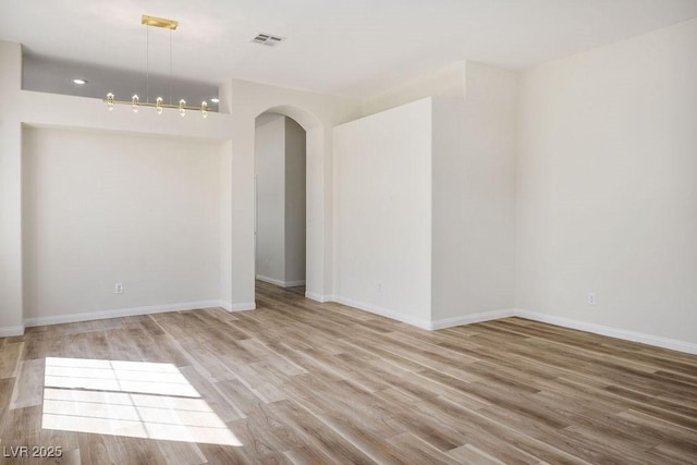 10657 Sapphire Vista Ave, Las Vegas, NV 89144 - empty room with visible vents, light wood-style floors, baseboards, and arched walkways