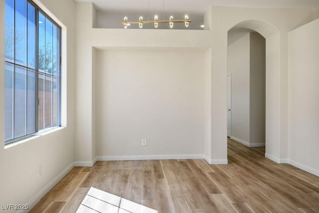 10657 Sapphire Vista Ave, Las Vegas, NV 89144 - unfurnished room with arched walkways, wood finished floors, and baseboards