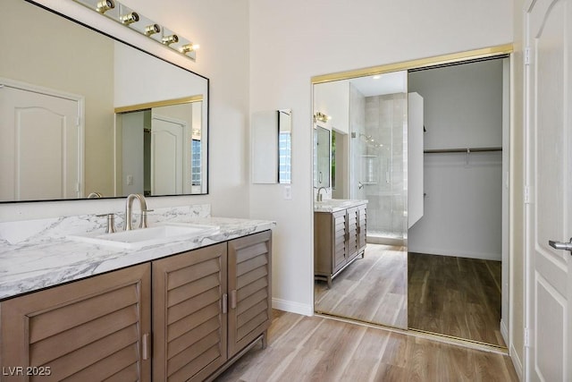 10657 Sapphire Vista Ave, Las Vegas, NV 89144 - bathroom with baseboards, wood finished floors, two vanities, and a sink