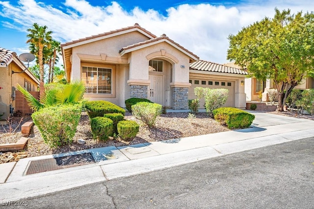 10657 Sapphire Vista Ave, Las Vegas, NV 89144 - mediterranean / spanish-style home featuring stucco siding, a tiled roof, driveway, stone siding, and an attached garage